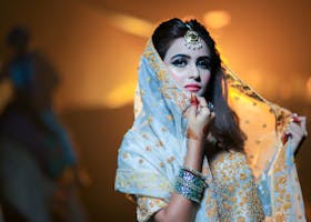 Beautiful Indian bride in traditional attire with intricate jewelry and makeup.
