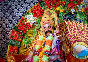 Colorful Indian performer in traditional costume at a Hindu festival in Odisha, India.