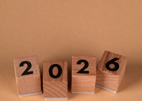Wooden blocks forming the year 2026 on a warm beige background, symbolizing the new year.