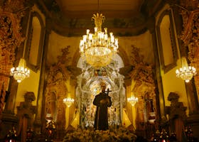 Captivating view of a baroque church interior featuring ornate carvings and a grand chandelier.
