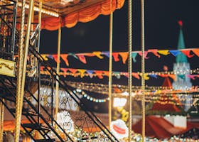 Enchanting carousel at night with colorful lights and decorations at a lively festival.