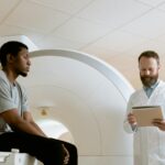 Doctor reviews patient's MRI results in a hospital setting, America Influenza Cases, America me Influenza ke Cases, America me Influenza ke kitne Cases hai, ab tak America me Influenza ke kitne Cases aaye hai, Loharu Doctors Strike,Loharu Doctors Strike, Haryana Doctors Protest, Gharaonda Hospital Incident, Doctor Assault Case, HCMS Association Strike, Government Hospital Loharu, Haryana Health News, Doctor Police Clash, Hospital OPD Closed, Haryana Breaking News