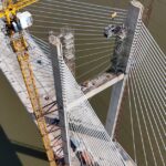 Aerial glance at a cable-stayed bridge under construction, showcasing yellow crane work over a river.Karnal elevated bridge, Smart City,